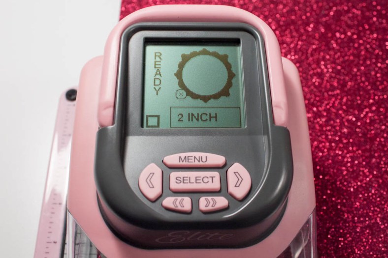 I made a 2-inch circle with a decorative edge in red glitter cardstock using my Slice and "Mistletoe" design card.